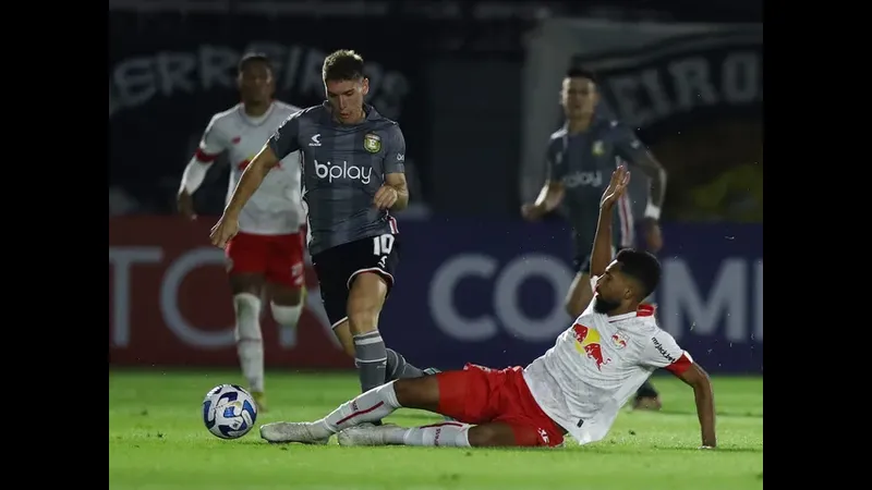 Cầu thủ của Platense vượt qua cầu thủ Deportivo Riestra để tiến gần khung thành đối phương Cầu thủ của Platense vượt qua cầu thủ Deportivo Riestra để tiến gần khung thành đối phương