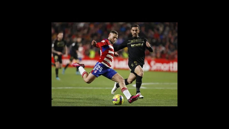 Cầu thủ của Tenerife vượt qua cầu thủ của Granada trong trận đấu bóng đá. Cầu thủ của Tenerife vượt qua cầu thủ của Granada trong trận đấu bóng đá.