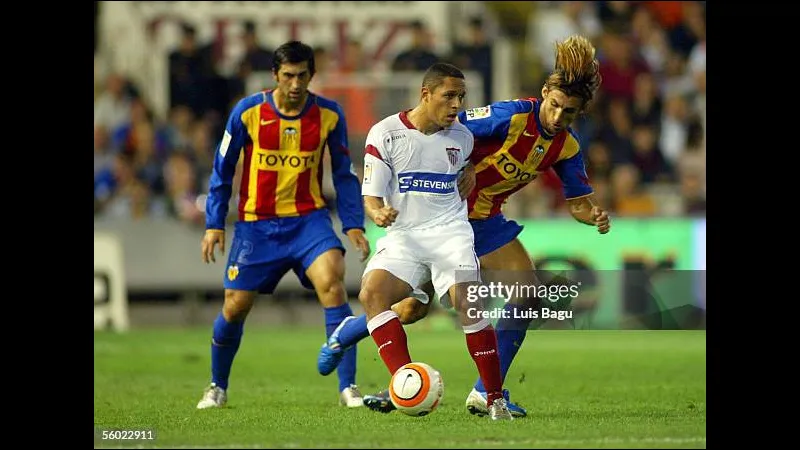 Cầu thủ Valencia chạy nhanh với bóng trước sự áp đảo từ hậu vệ của Sevilla Cầu thủ Valencia chạy nhanh với bóng trước sự áp đảo từ hậu vệ của Sevilla